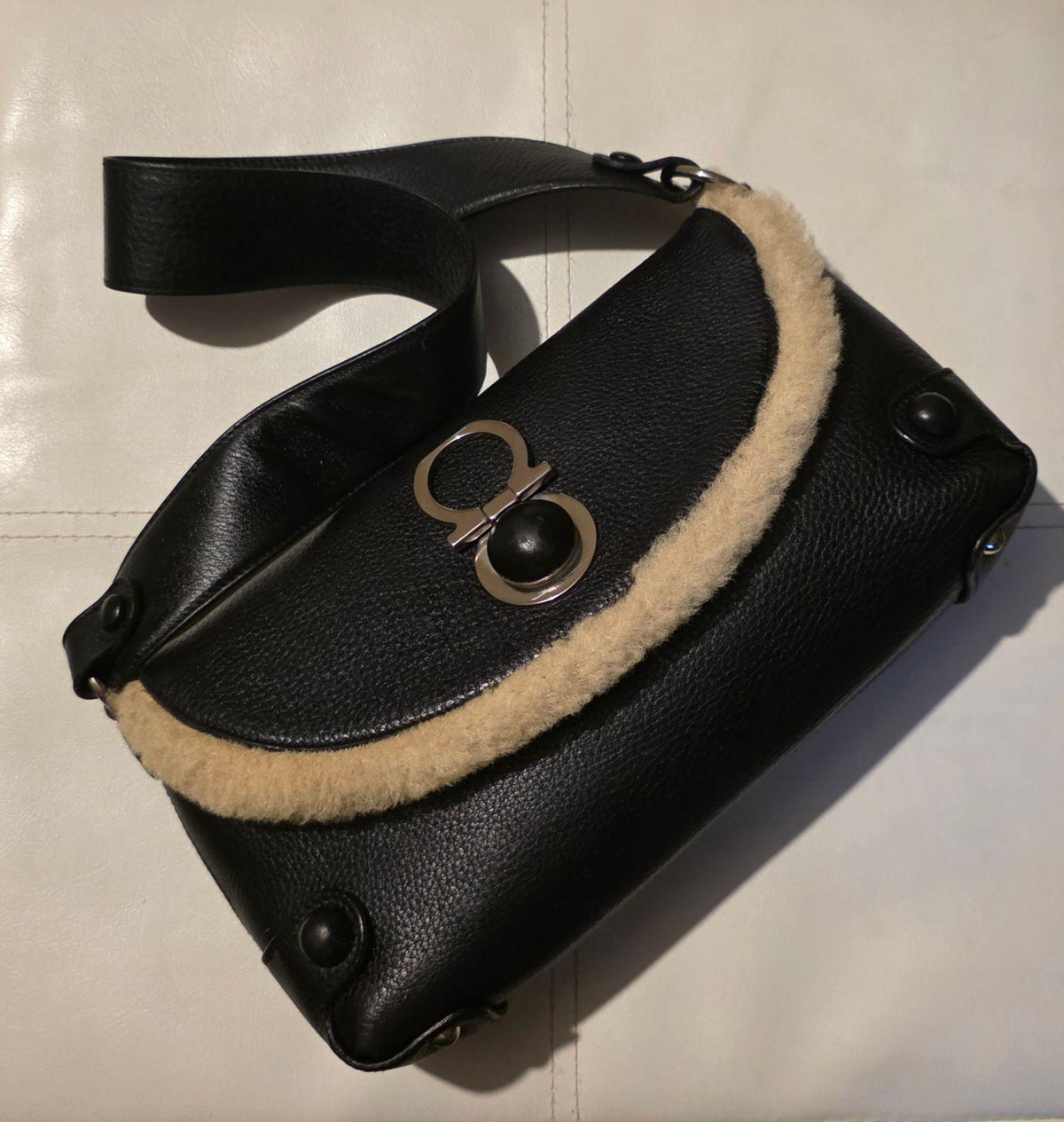 Salvatore Ferragamo black leather purse with shearling trim and Gancini hardware.