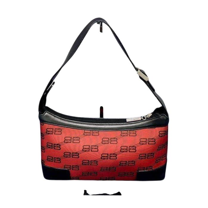Balenciaga black and red shoulder bag with signature monogram and adjustable strap.