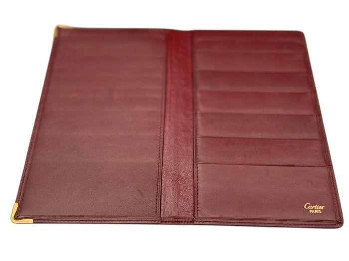 Cartier bifold wallet burgundy Bordeaux leather with gold-plated corners and 'Cartier Paris' logo.