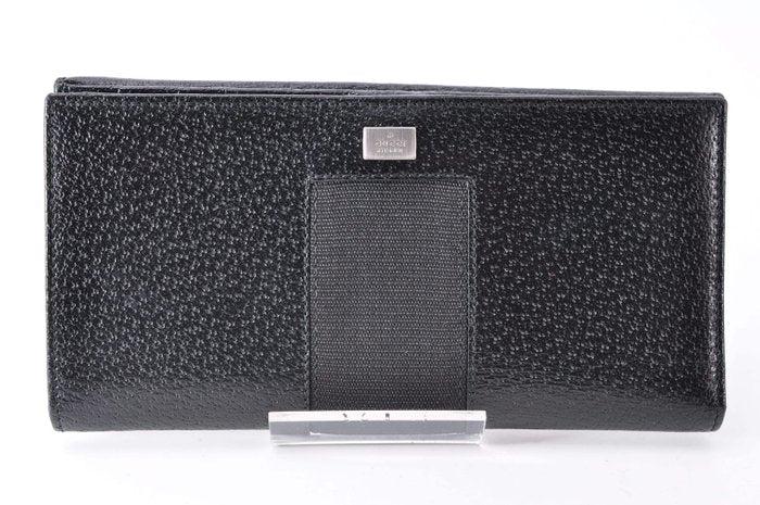 Gucci black leather zip around wallet with gold tone hardware and minimalist design.