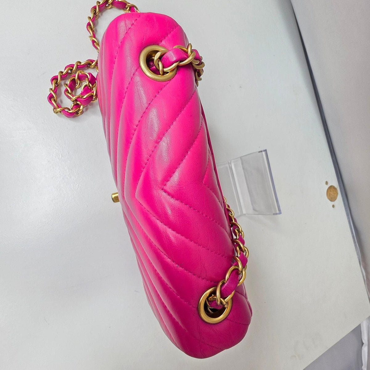 Chanel pink mini messenger bag in chevron leather with gold CC clasp and hardware.
