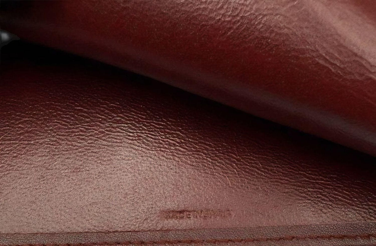 Cartier bifold wallet burgundy Bordeaux leather with gold-plated corners and 'Cartier Paris' logo.