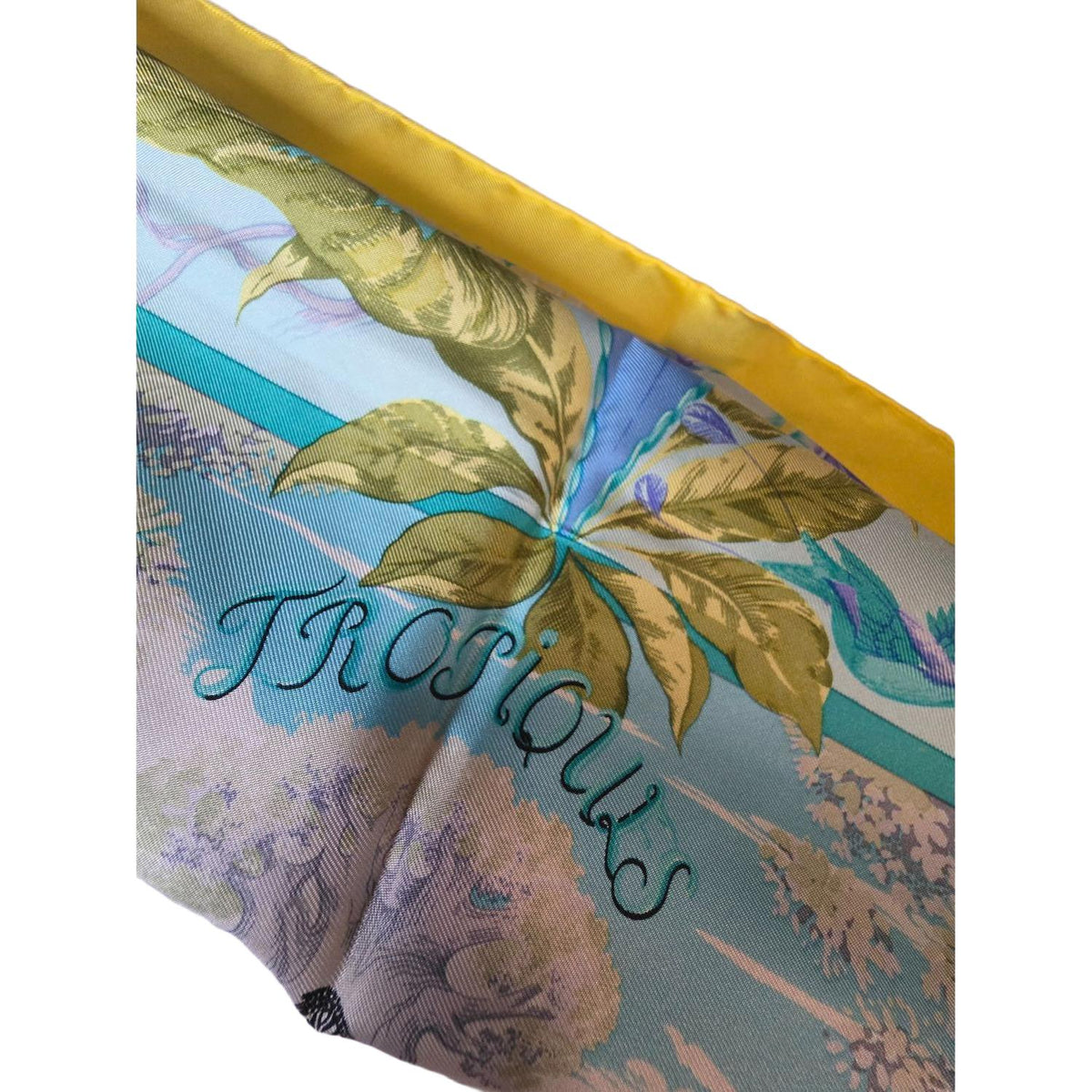 Hermès yellow silk twill shawl featuring tropical animal prints and hand-rolled edges.