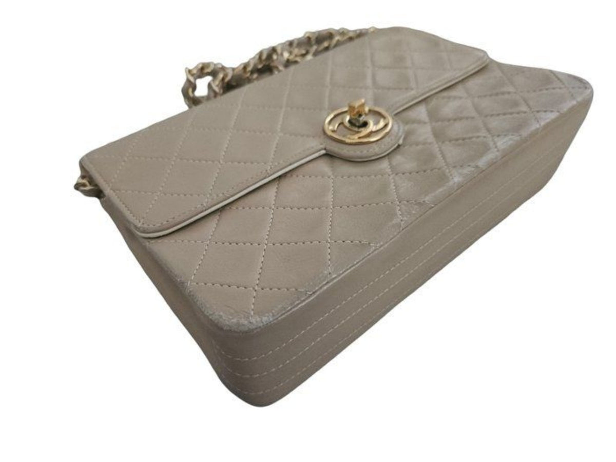 Chanel beige quilted leather flap bag with gold hardware and interlocking CC turn-lock.