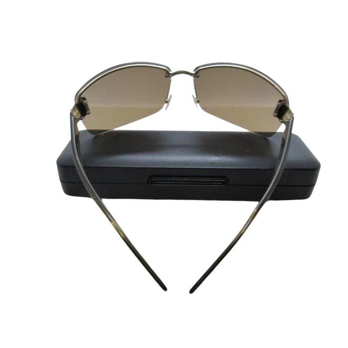 Gucci half-rim wrap sunglasses in green and gold, featuring vintage design and logo.