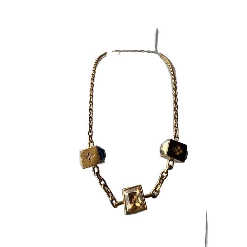 Louis Vuitton gold necklace with monogram dice charms and sparkling crystals.