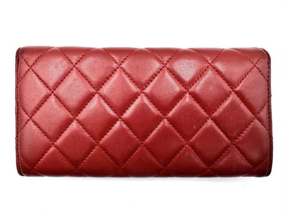Chanel red quilted leather wallet with CC logo and fabric-lined interior.