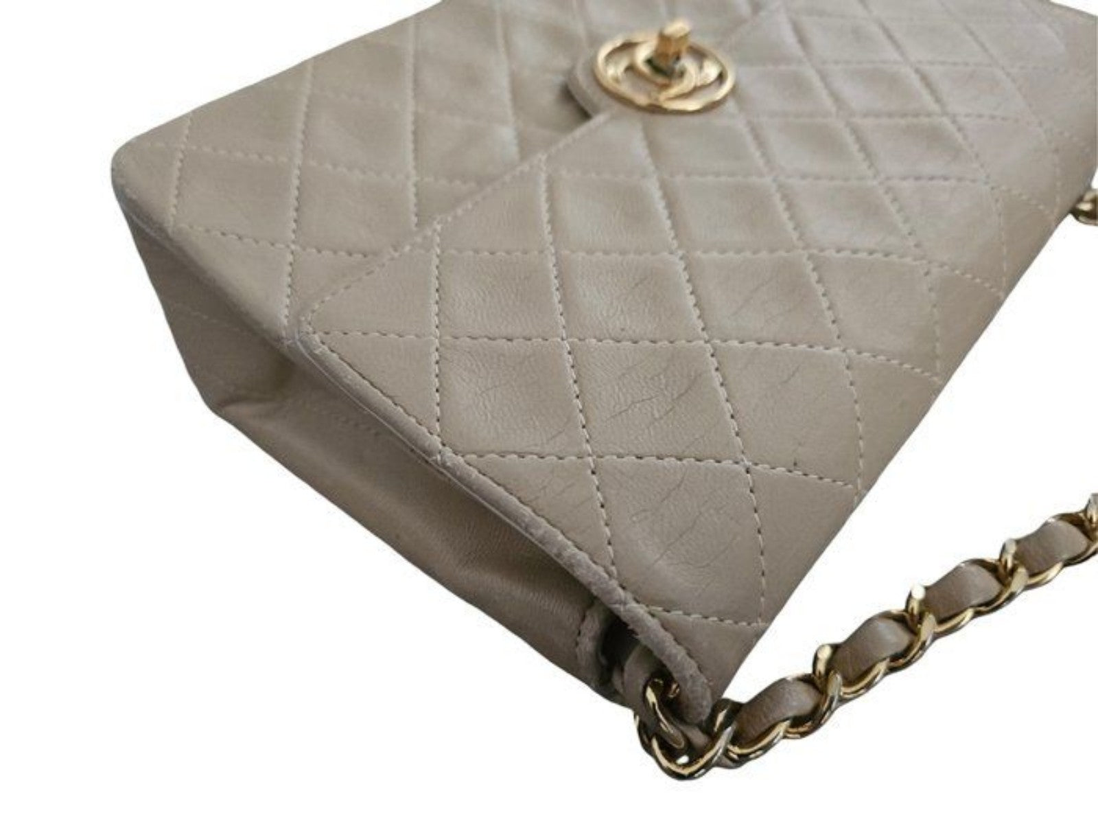 Chanel beige quilted leather flap bag with gold hardware and interlocking CC turn-lock.