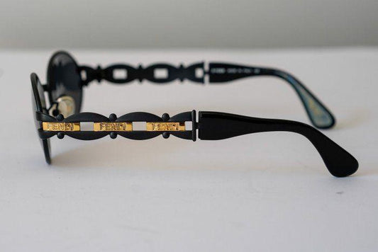 Fendi black and gold sunglasses with logo detail, high-quality plastic and metal frame.