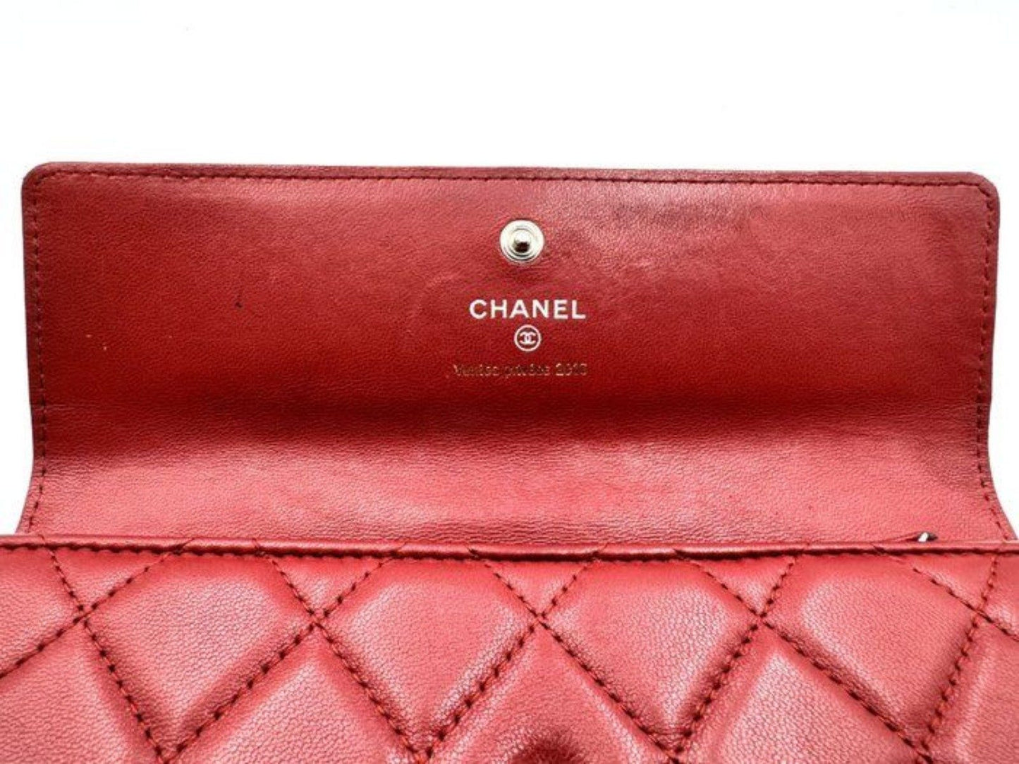 Chanel red quilted leather wallet with CC logo and fabric-lined interior.