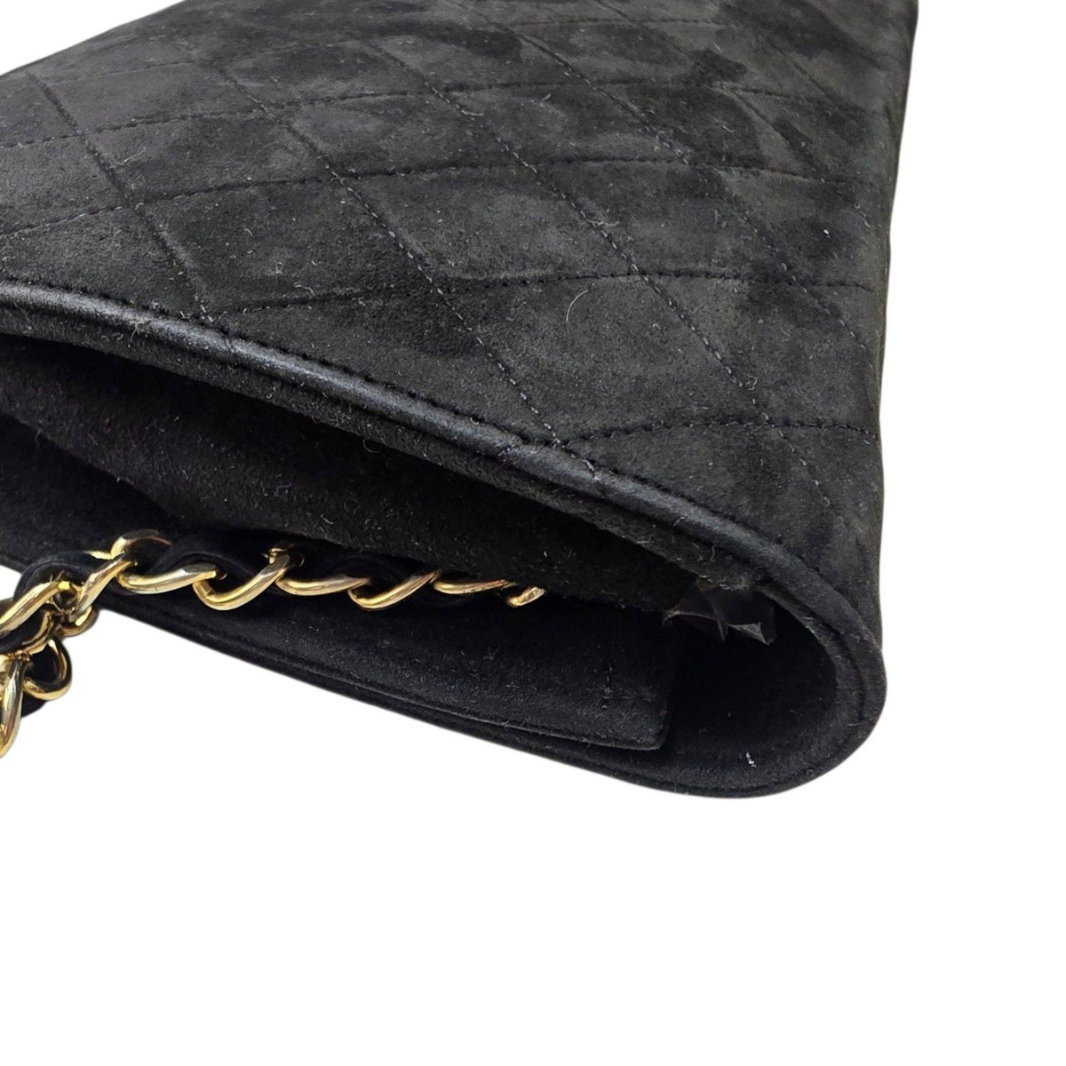 Chanel black quilted suede crossbody bag with gold chain and leather woven strap.
