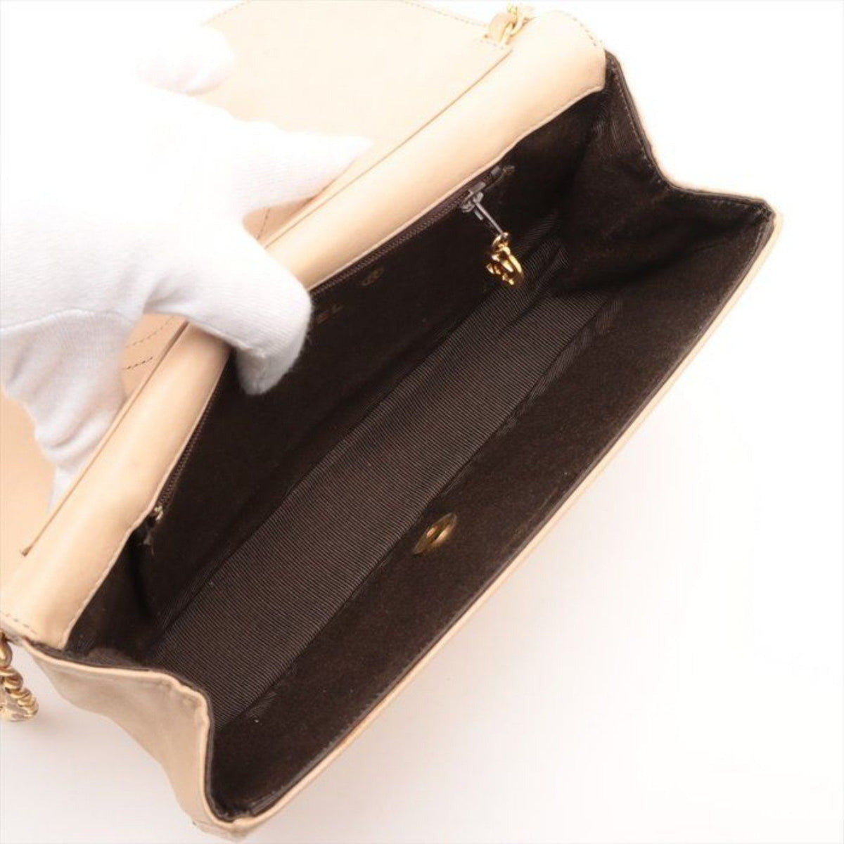 CHANEL beige matelassé leather half moon shoulder bag with gold hardware and classic logo.