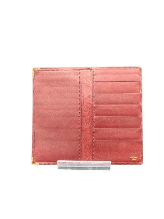 Cartier bifold wallet burgundy Bordeaux leather with gold-plated corners and 'Cartier Paris' logo.