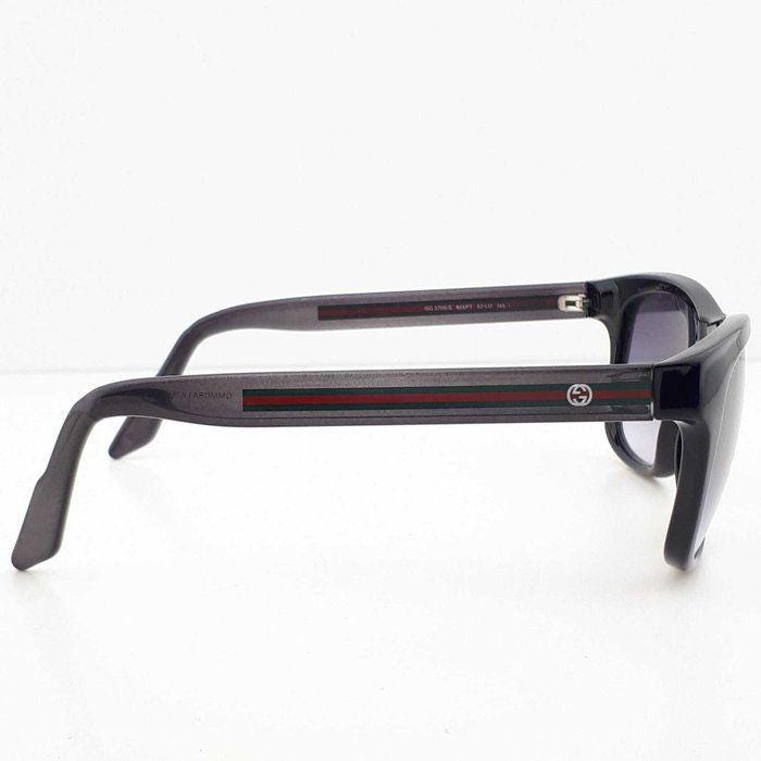 Gucci black Wayfarer sunglasses with grey gradient lenses and red-green striped temples.