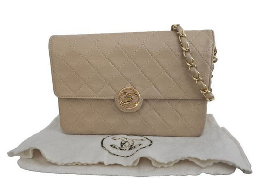 Chanel beige quilted leather flap bag with gold hardware and interlocking CC turn-lock closure.