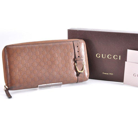 Gucci brown leather zip around wallet with gold tone hardware and smooth finish.