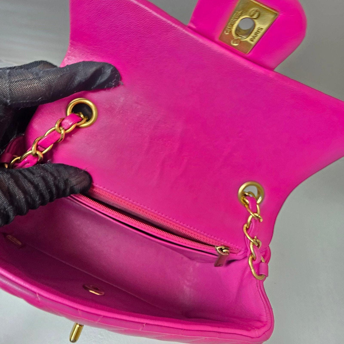 Chanel pink mini messenger bag in chevron leather with gold CC clasp and hardware.
