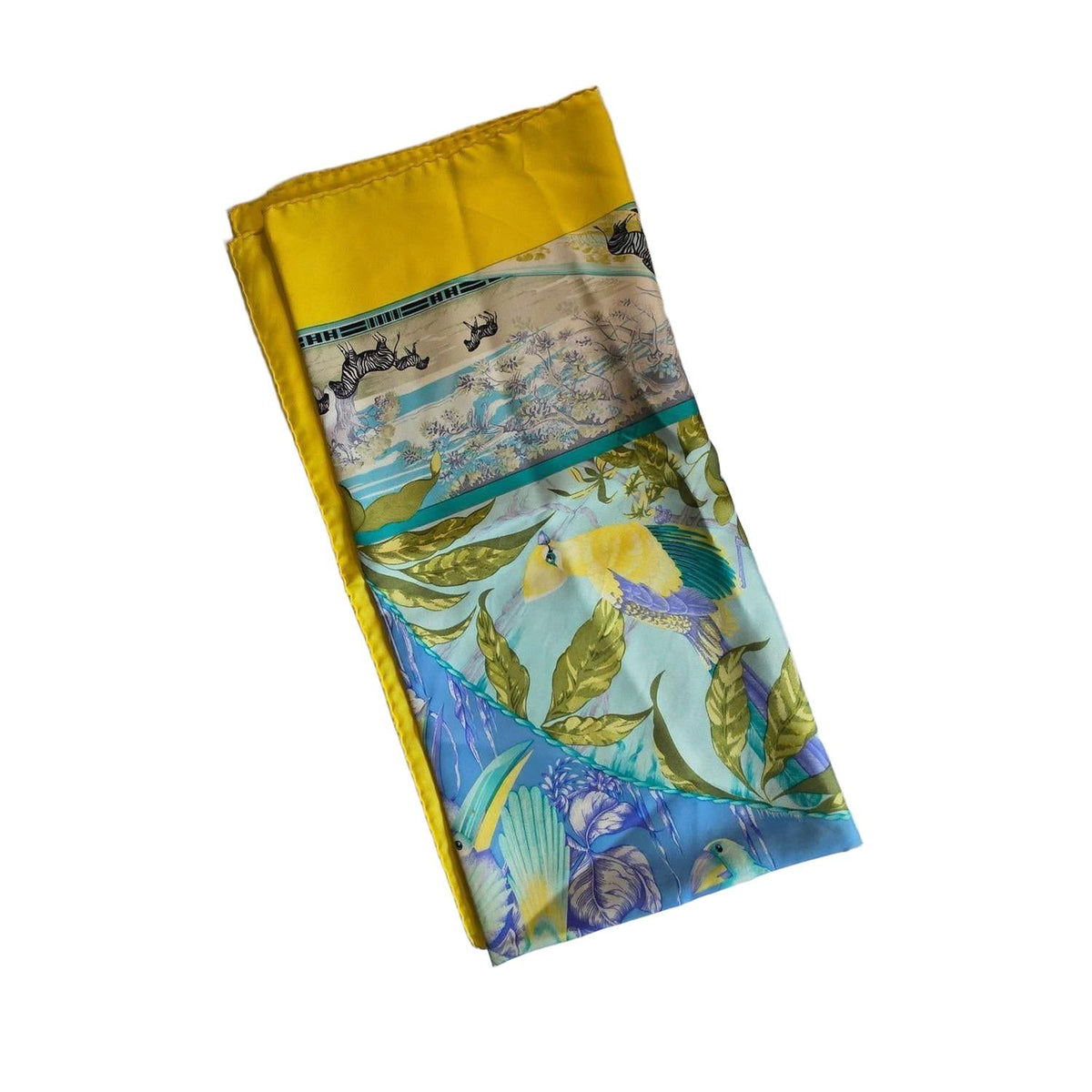 Hermès yellow silk twill shawl featuring tropical animal prints and hand-rolled edges.