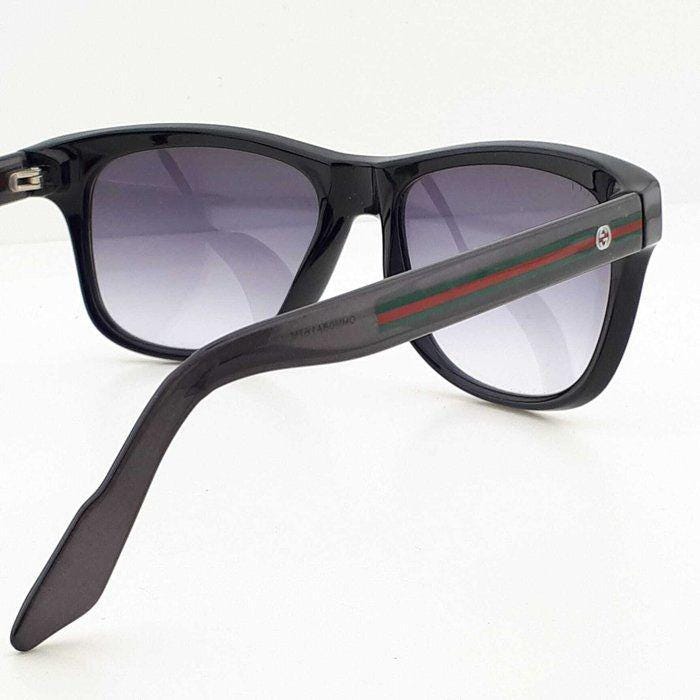 Gucci black Wayfarer sunglasses with grey gradient lenses and red-green striped temples.