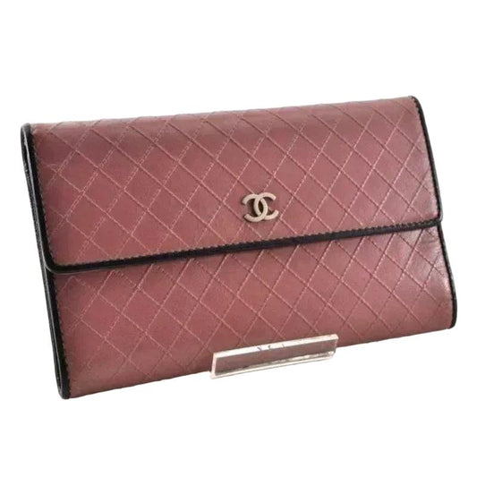 Chanel bifold wallet bordeaux leather with embossed logo and sleek design.