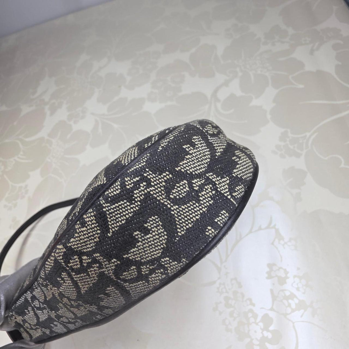 Dior messenger bag in grey, blue, and black with silver accents and saddle shape.