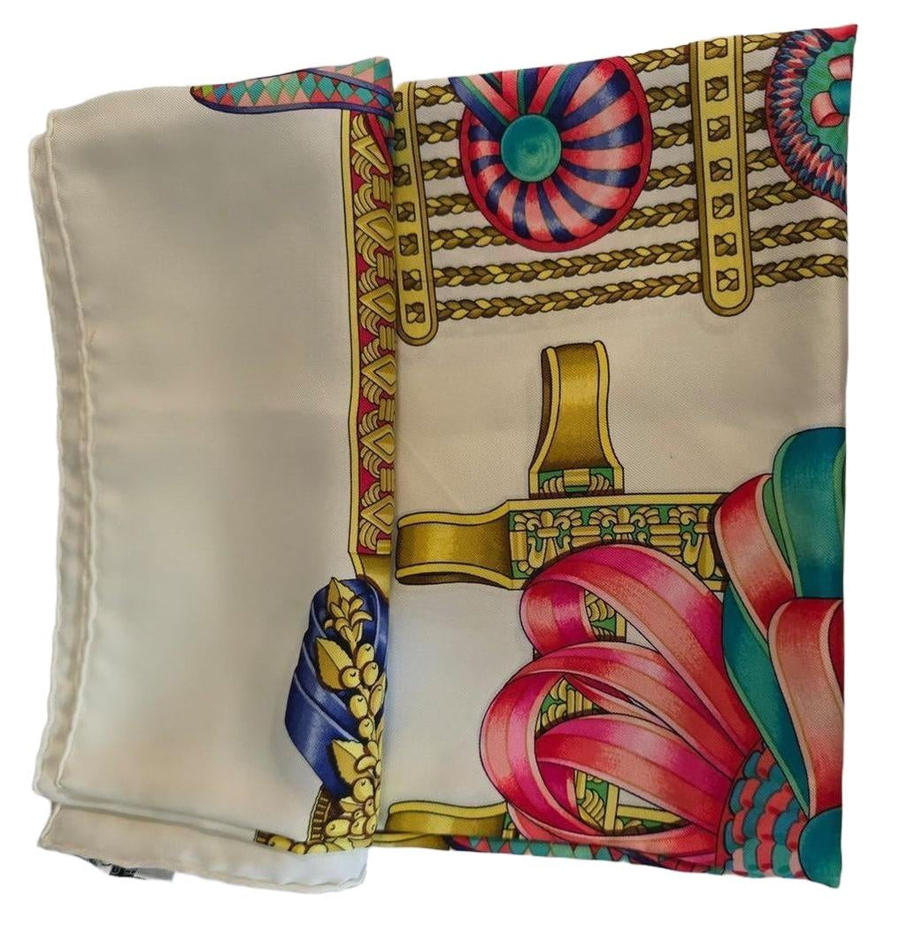 Hermès beige silk scarf featuring equestrian ribbon pattern and hand-rolled edges.