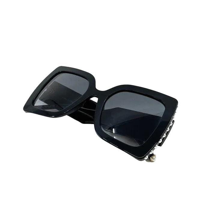 Carolina Herrera black acetate sunglasses with grey lenses and signature logo detailing.