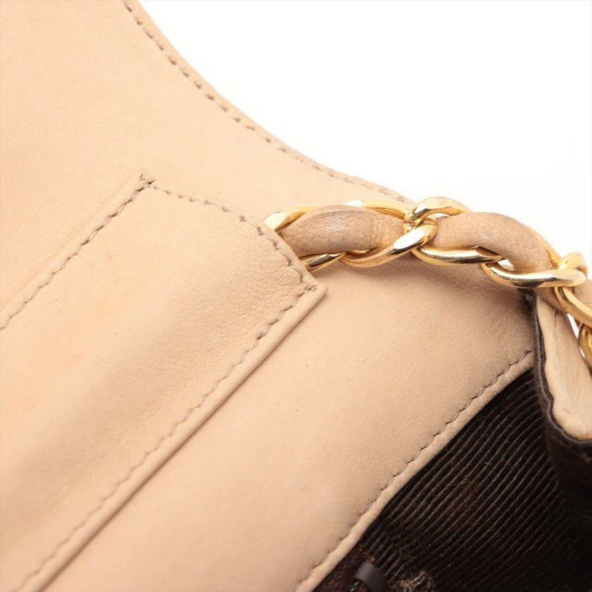 CHANEL beige matelassé leather half moon shoulder bag with gold hardware and classic logo.
