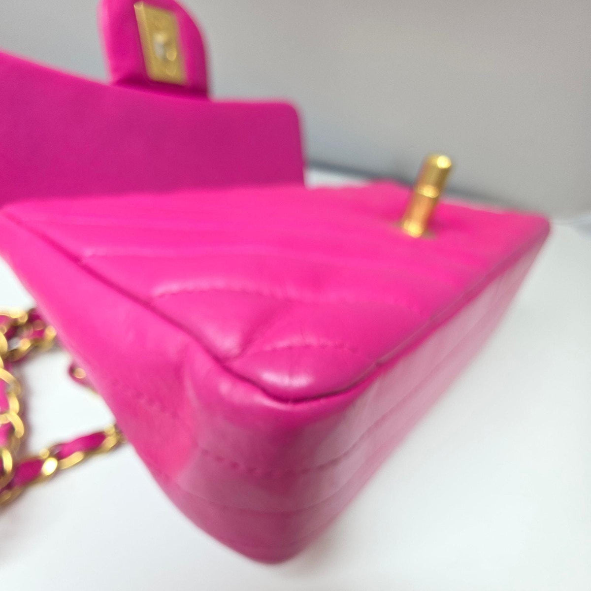 Chanel pink mini messenger bag in chevron leather with gold CC clasp and hardware.