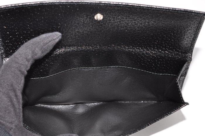 Gucci black leather zip around wallet with gold tone hardware and minimalist design.