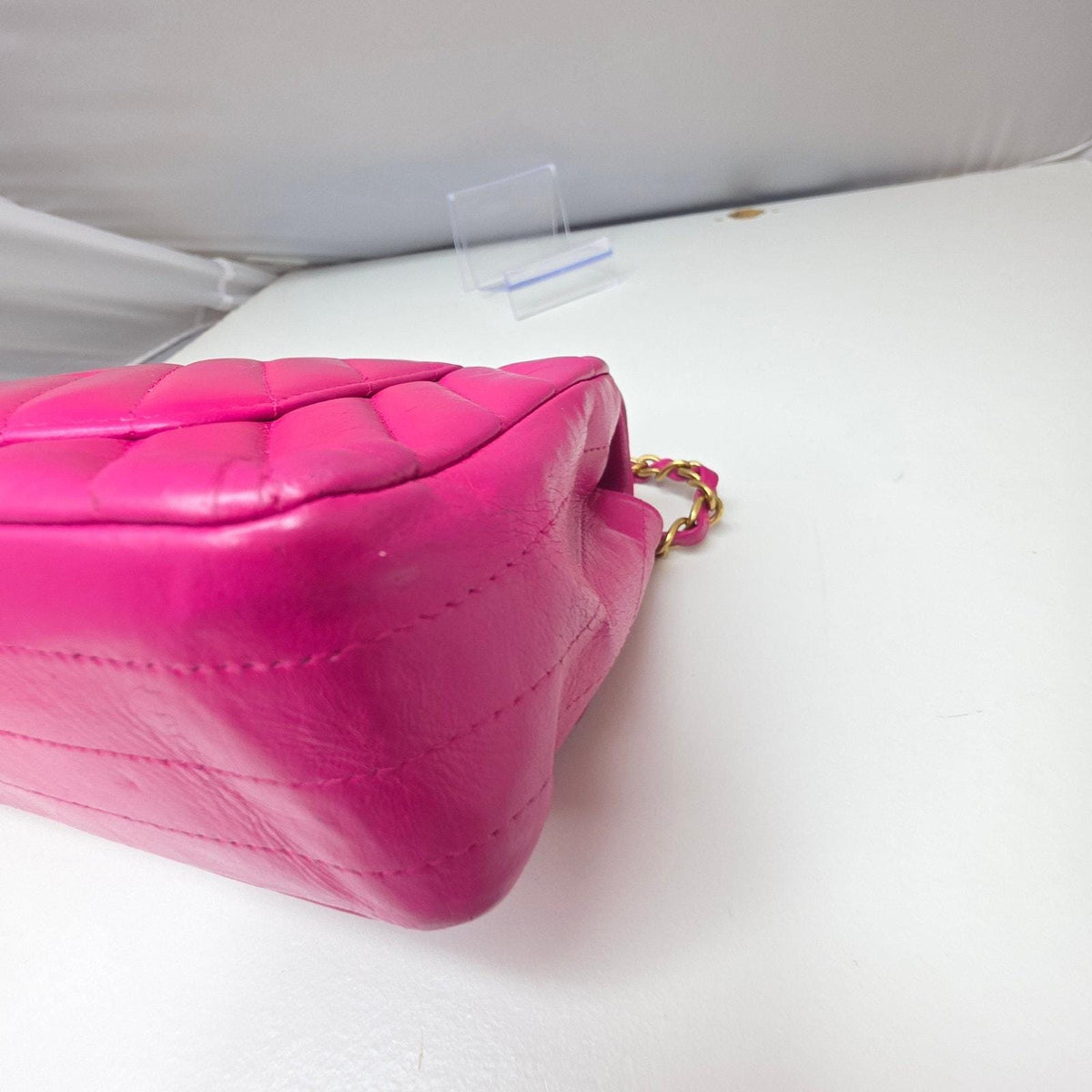 Chanel pink mini messenger bag in chevron leather with gold CC clasp and hardware.