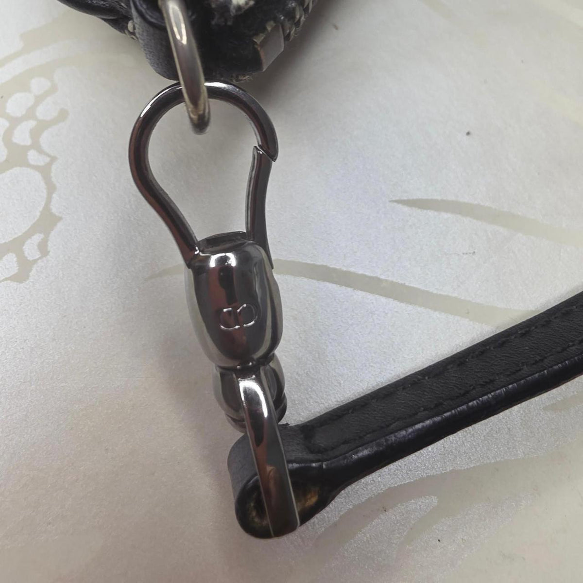 Dior messenger bag in grey, blue, and black with silver accents and saddle shape.