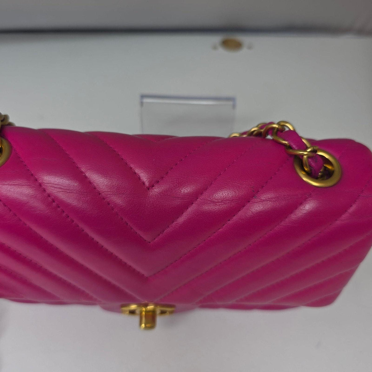 Chanel pink mini messenger bag in chevron leather with gold CC clasp and hardware.