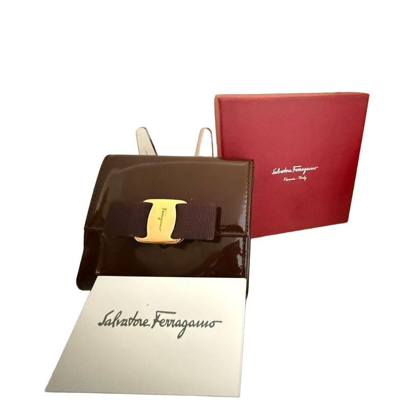Salvatore Ferragamo burgundy wallet patent leather with gold Vara bow detail.