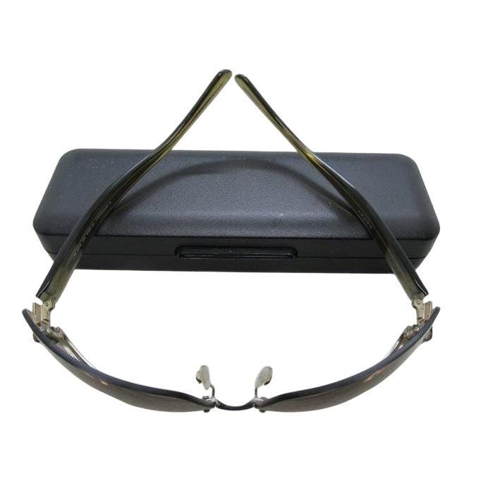 Gucci half-rim wrap sunglasses in green and gold, featuring vintage design and logo.