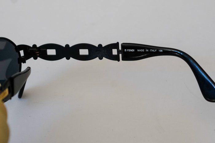 Fendi black and gold sunglasses with logo detail, high-quality plastic and metal frame.