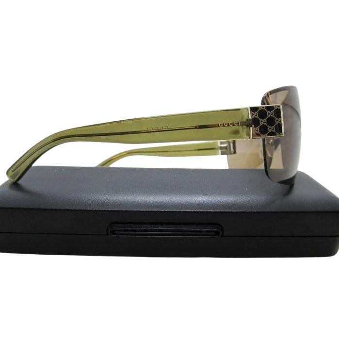Gucci half-rim wrap sunglasses in green and gold, featuring vintage design and logo.