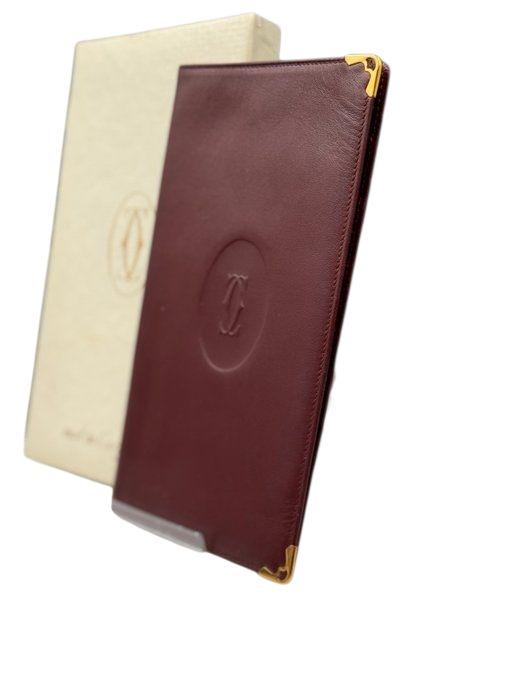 Cartier bifold wallet burgundy Bordeaux leather with gold-plated corners and 'Cartier Paris' logo.
