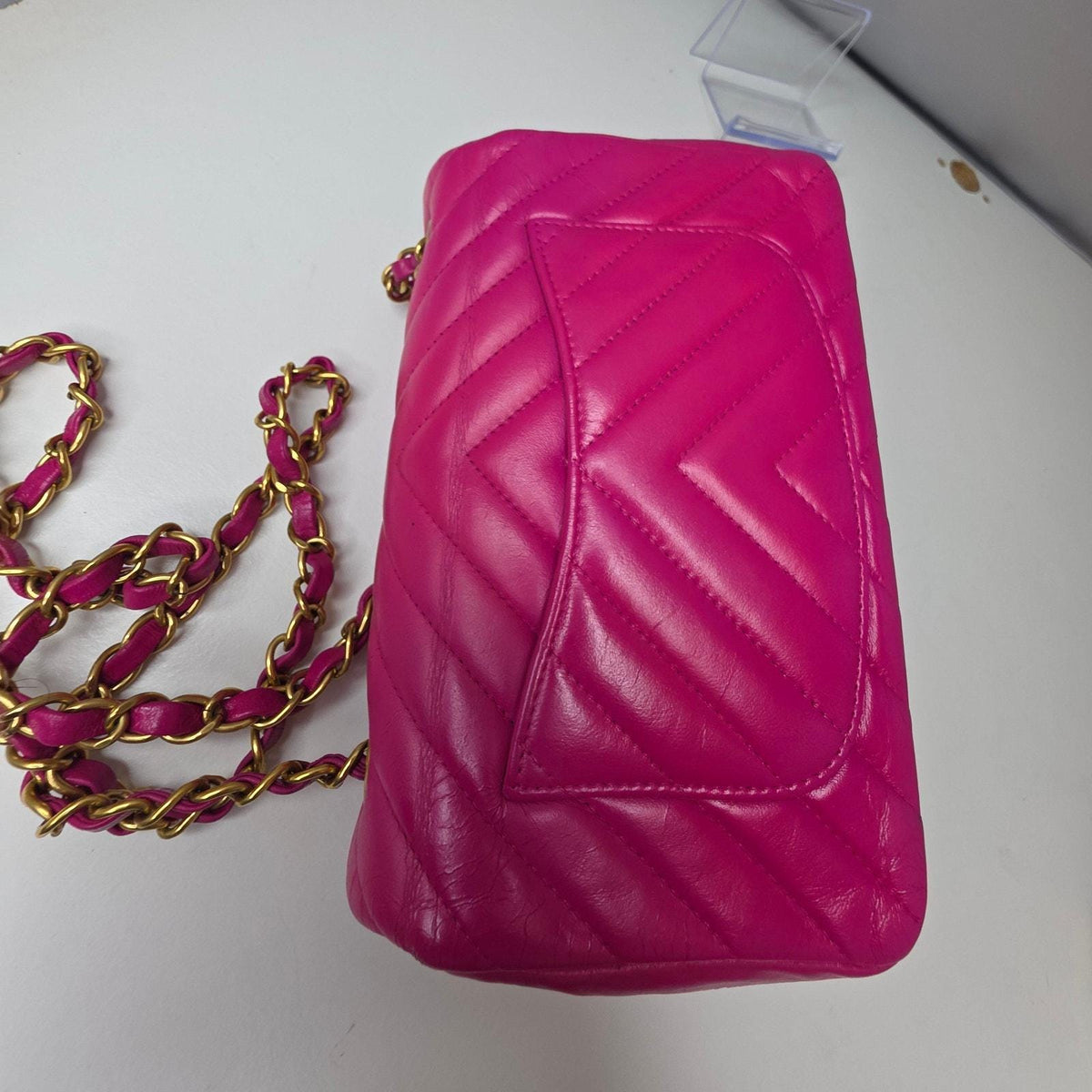 Chanel pink mini messenger bag in chevron leather with gold CC clasp and hardware.