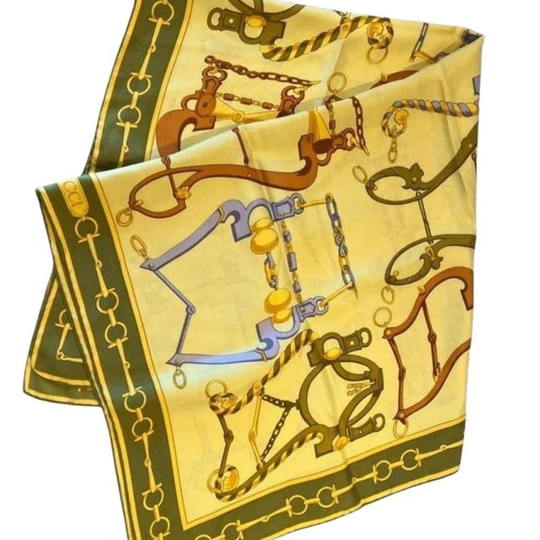 Gucci silk scarf featuring vintage equestrian print in gold, green, and yellow.