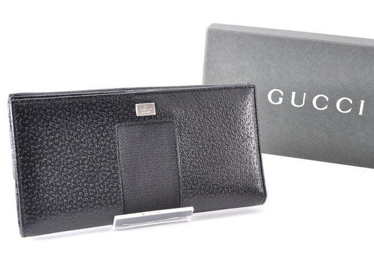 Gucci black leather zip around wallet with gold tone hardware and minimalist design.