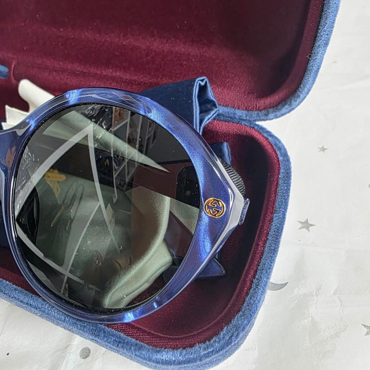 Gucci blue sunglasses with black lenses, featuring logo and giftable condition.