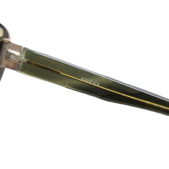 Gucci half-rim wrap sunglasses in green and gold, featuring vintage design and logo.