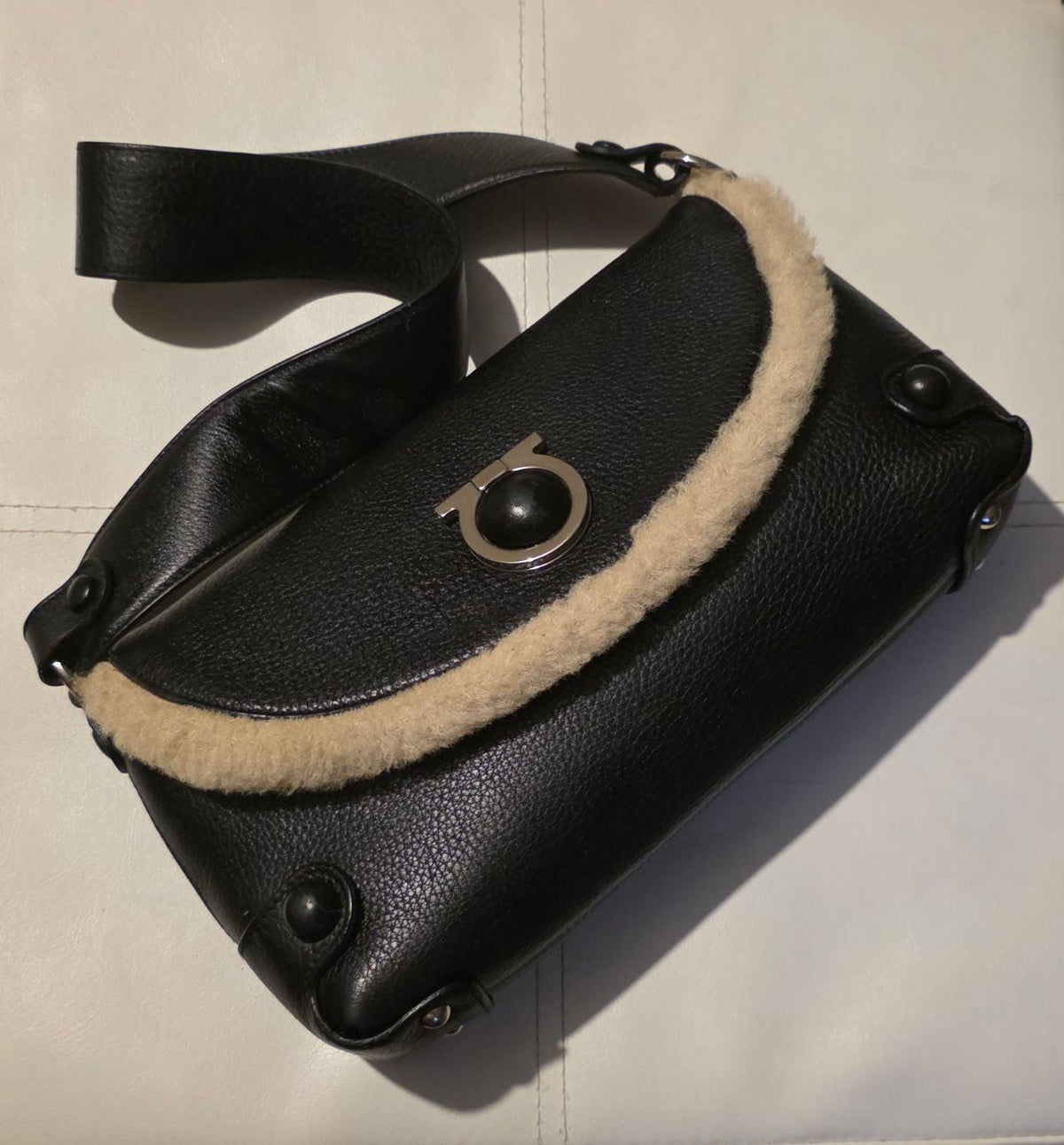 Salvatore Ferragamo black leather purse with shearling trim and Gancini hardware.