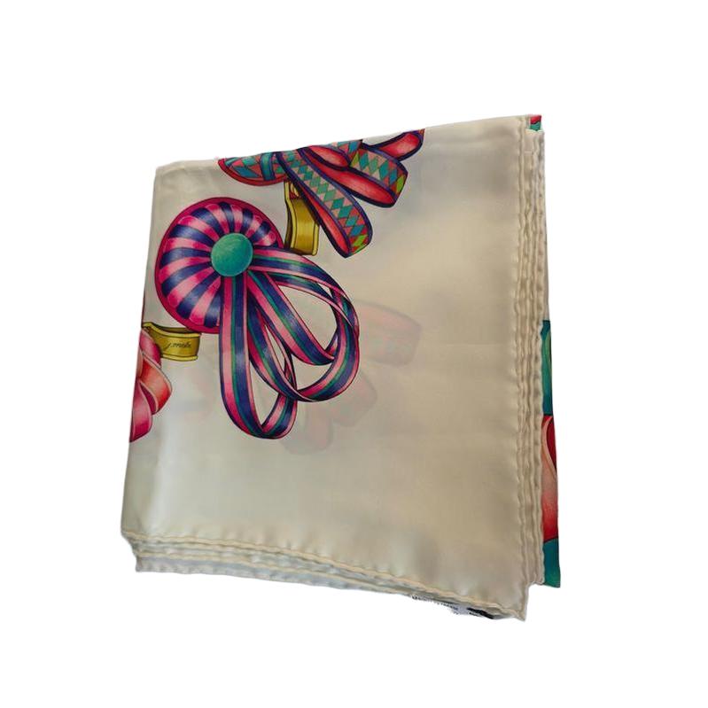Hermès beige silk scarf featuring equestrian ribbon pattern and hand-rolled edges.