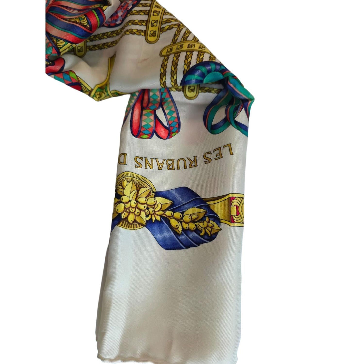 Hermès beige silk scarf featuring equestrian ribbon pattern and hand-rolled edges.