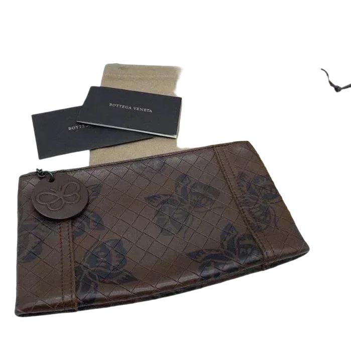 Bottega Veneta brown leather pouch with intrecciato weave and zip-around closure.