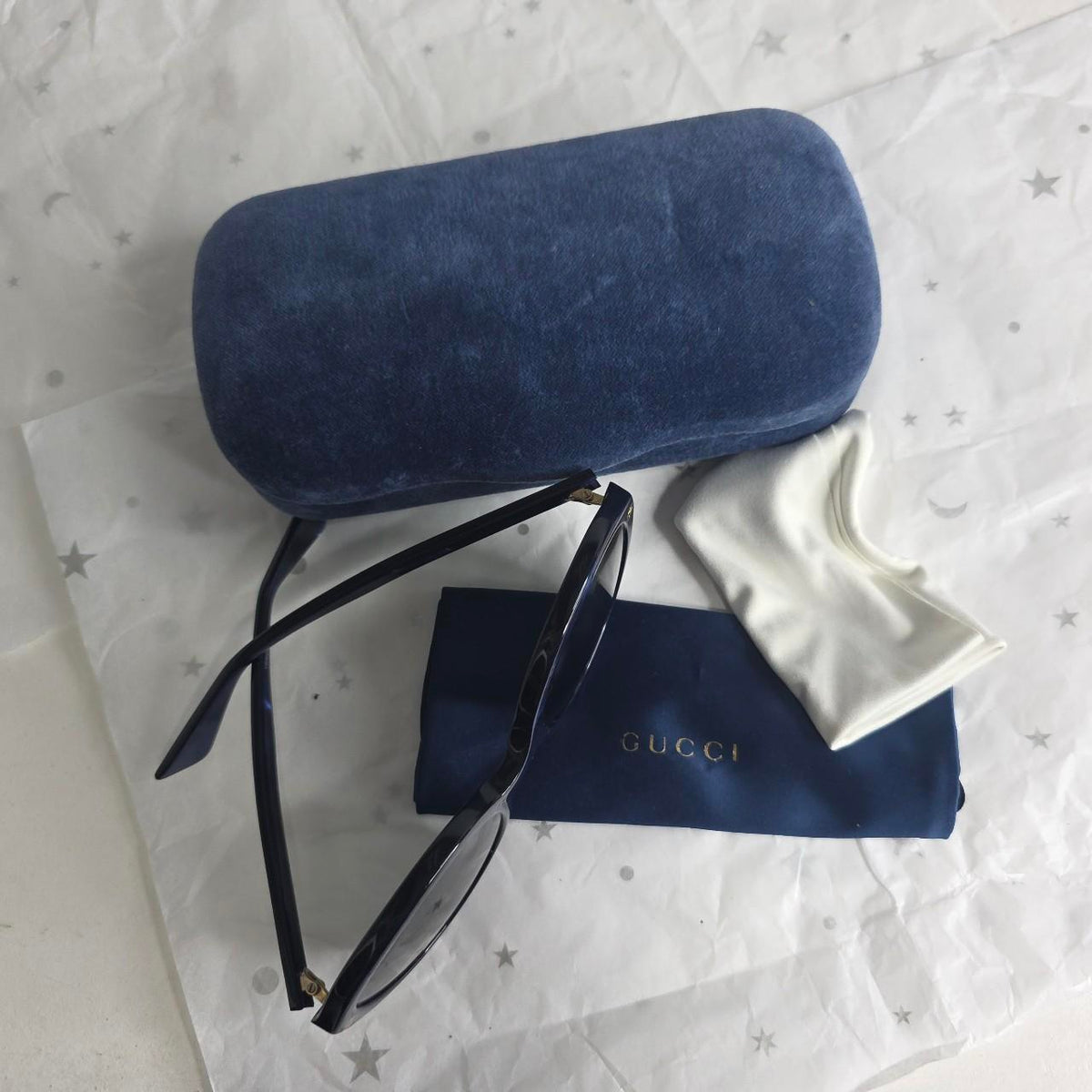 Gucci blue sunglasses with black lenses, featuring logo and giftable condition.