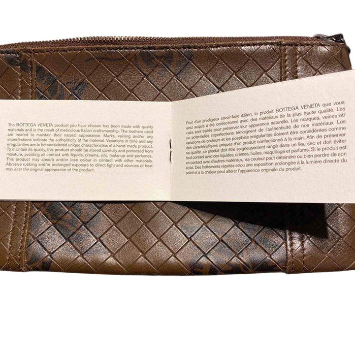 Bottega Veneta brown leather pouch with intrecciato weave and zip-around closure.