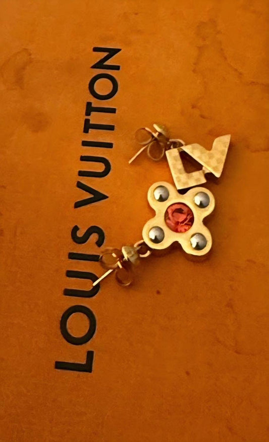 Louis Vuitton gold earrings with red stone and iconic monogram flower motif.